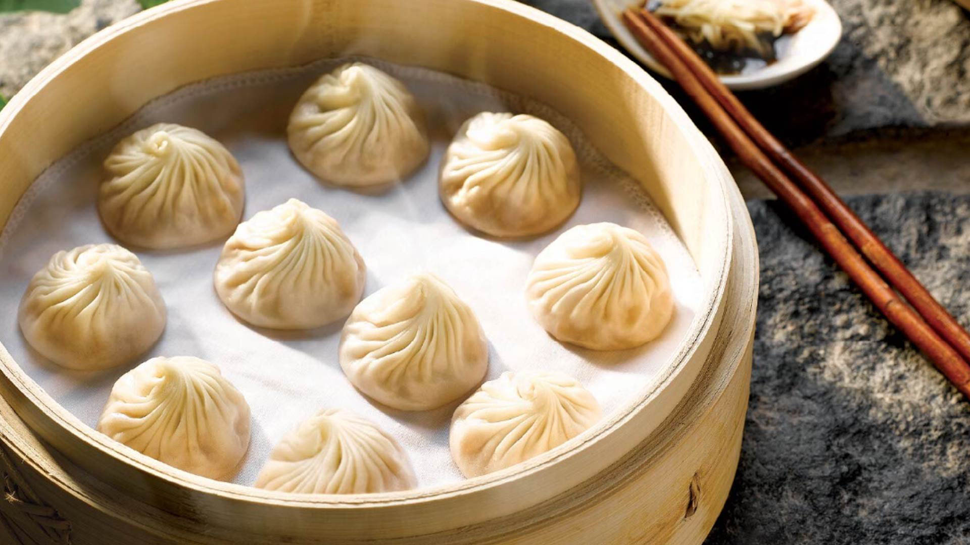 Satu keranjang steamed pork dumplings, xiao long baos