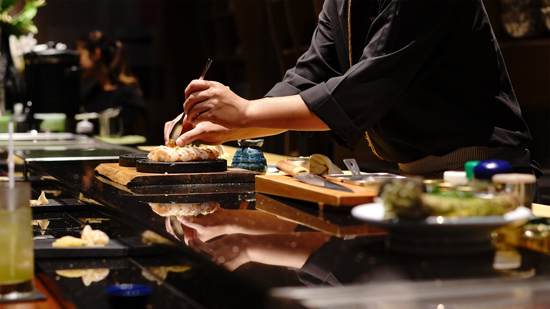 Chef membuat sushi untuk bersantap omakase di Singapura