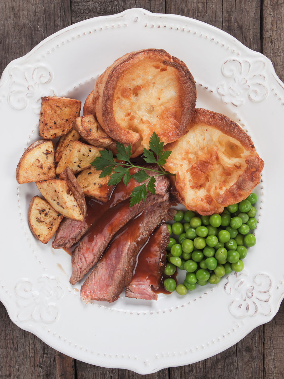 Roasted beef with Yorkshire pudding and vegetables di atas piring di restoran Sunday roast terbaik di Singapura