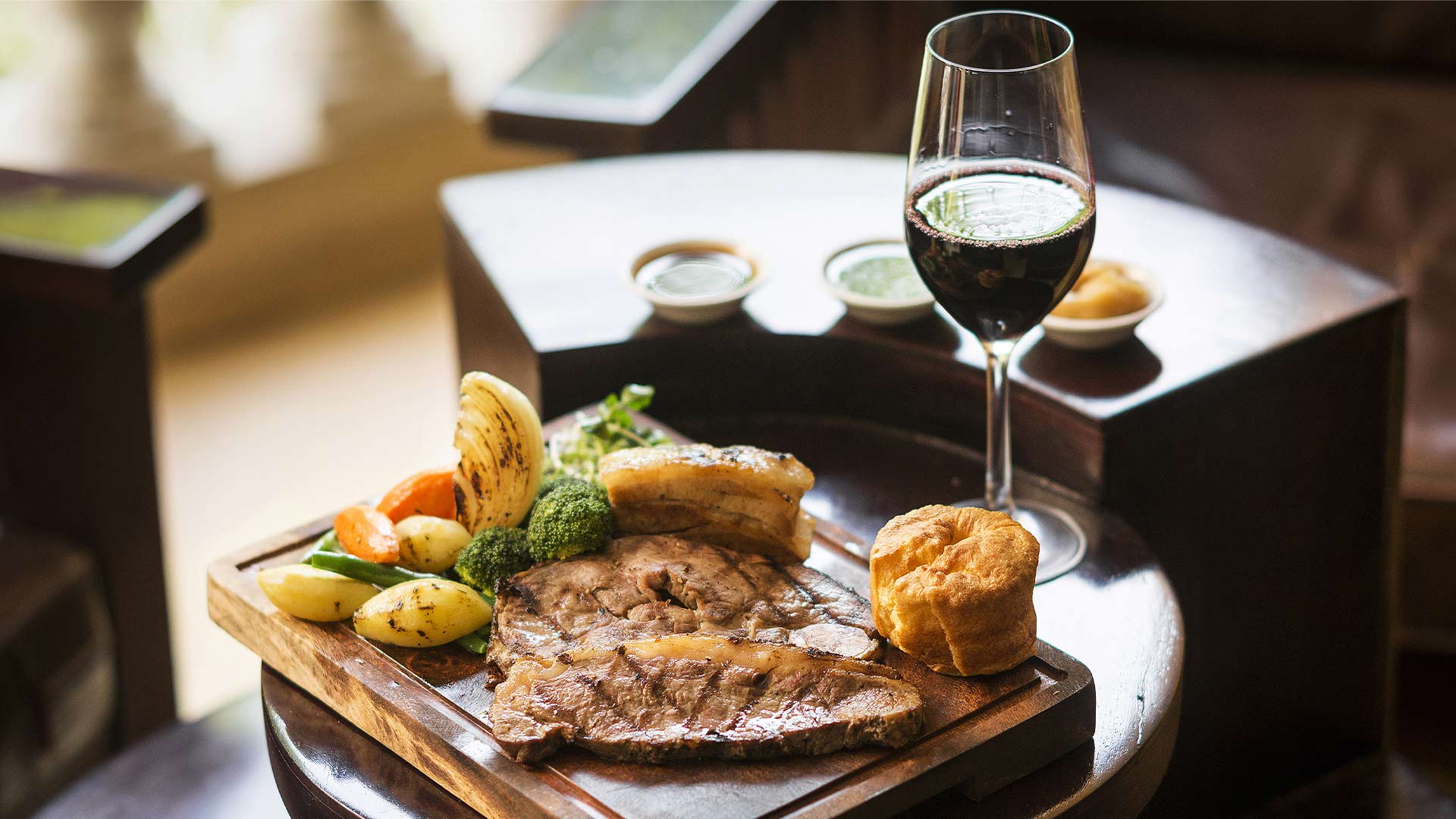 Roasted lamb with vegetables, puding, dan segelas anggur merah di restoran Sunday roast terbaik di Singapura
