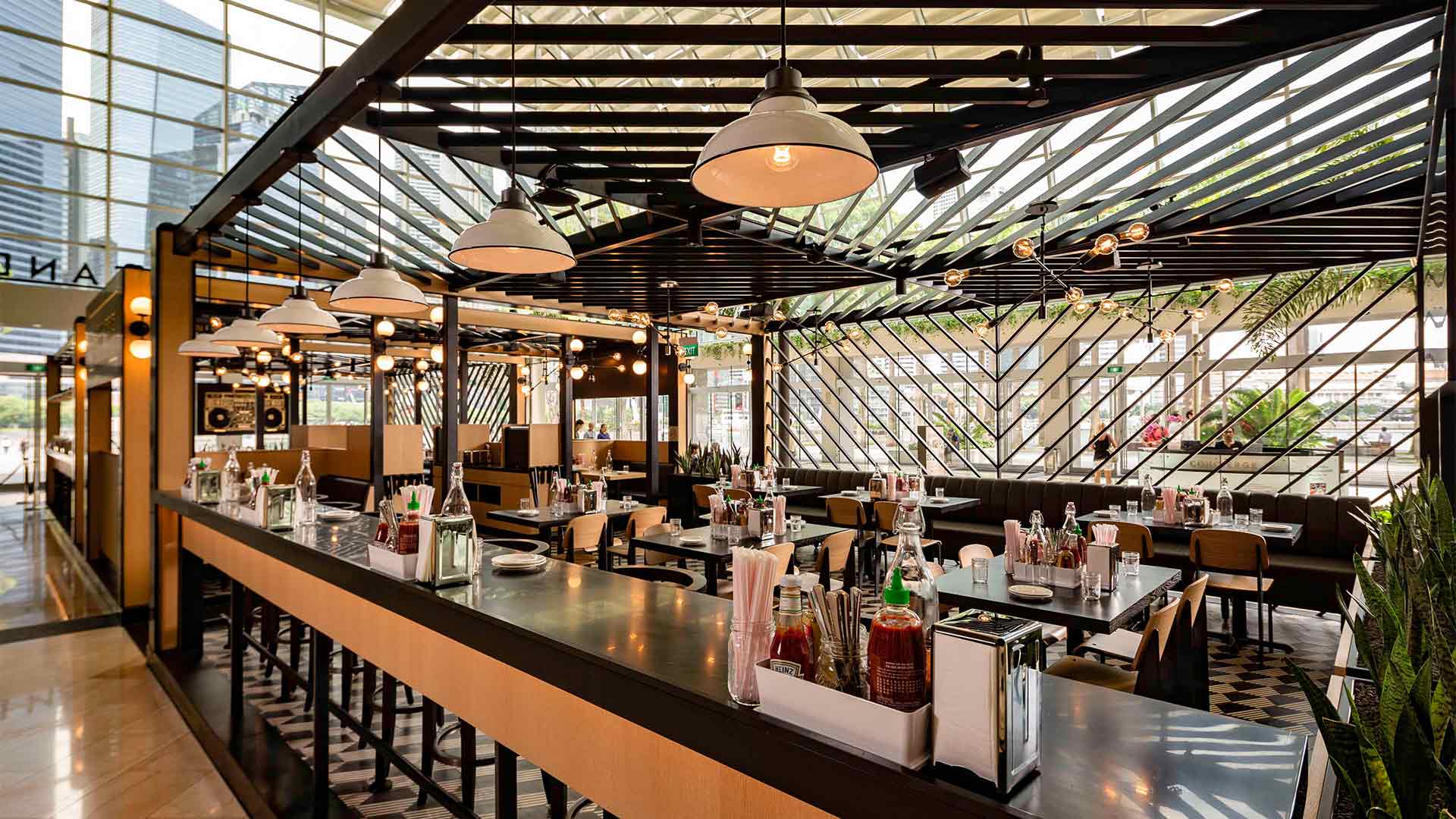 Area bersantap atrium di Black Tap, restoran ideal untuk acara dan bersantap privat di Singapura