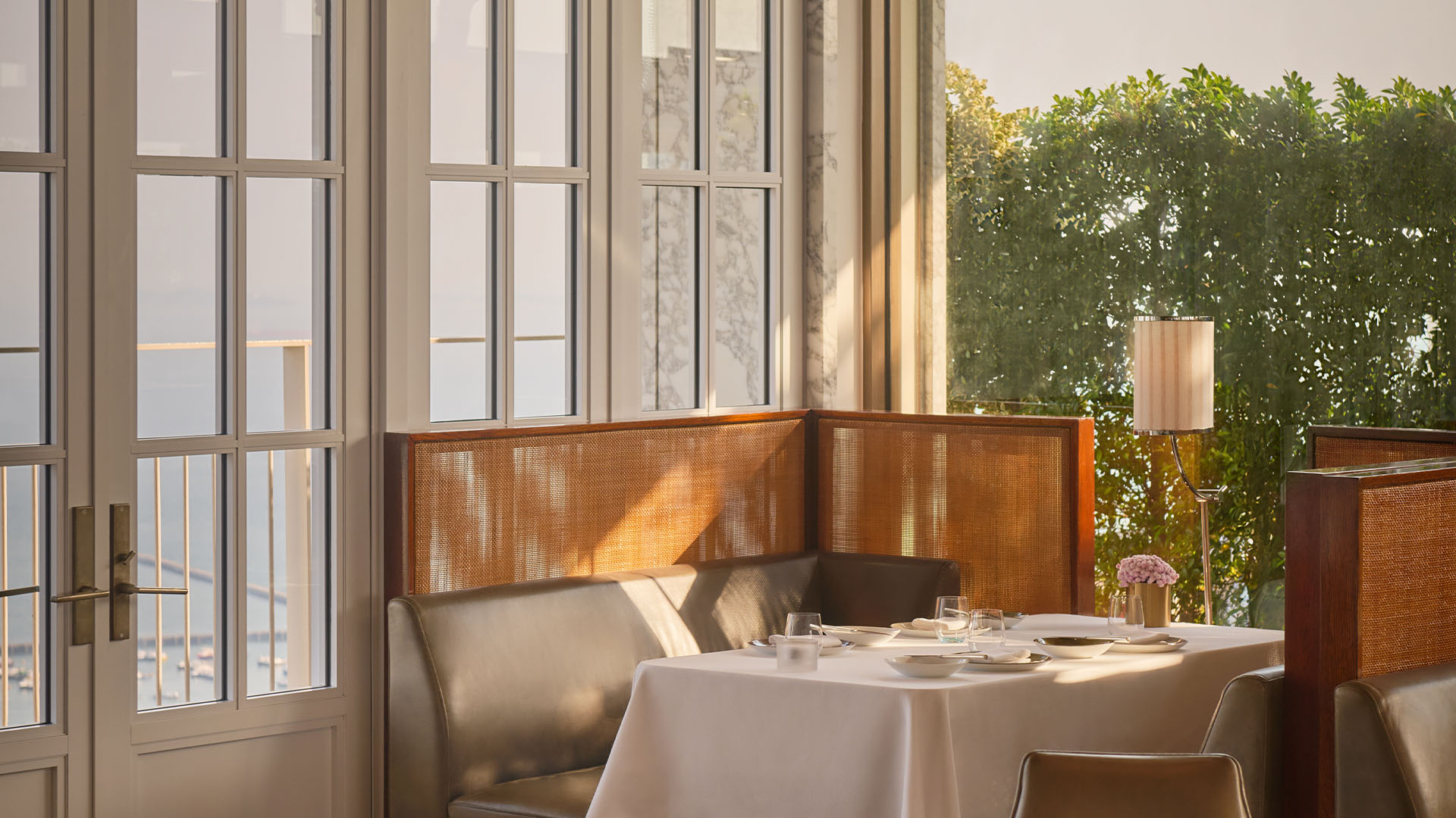 Area bersantap di Spago, restoran teras atap, dengan pemandangan pelabuhan dari ketinggian lantai 57.