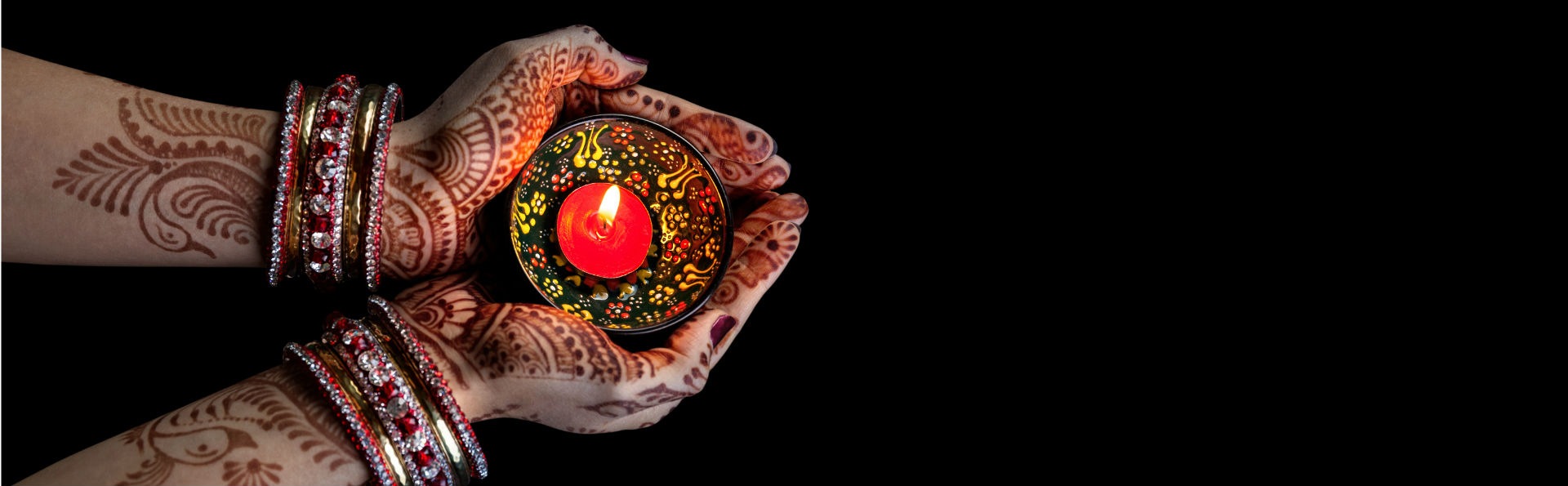 henna hands holding tea light on diwali